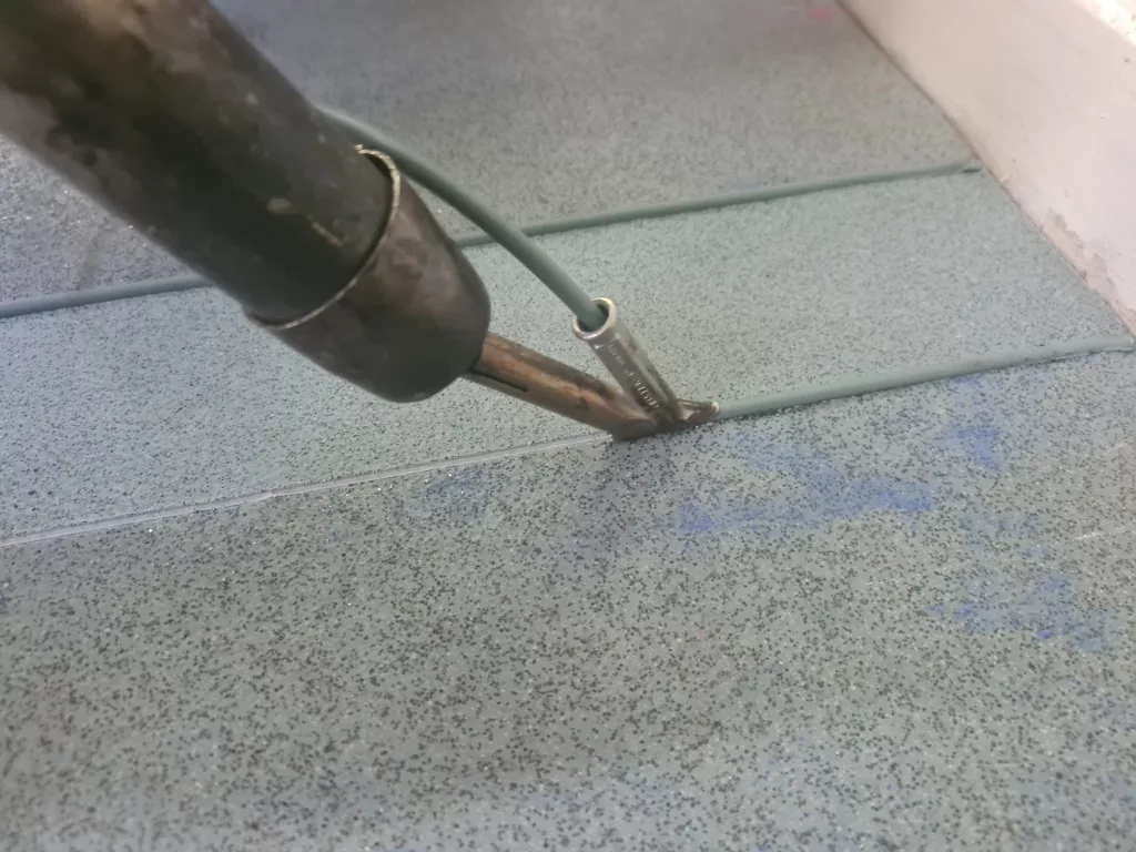 Altro safety flooring school classroom. hot welding seams with a heat gun.